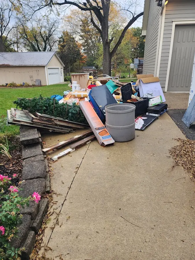 Dumpster being loaded with debris for Roofing Dumpster Rental in Norwood
